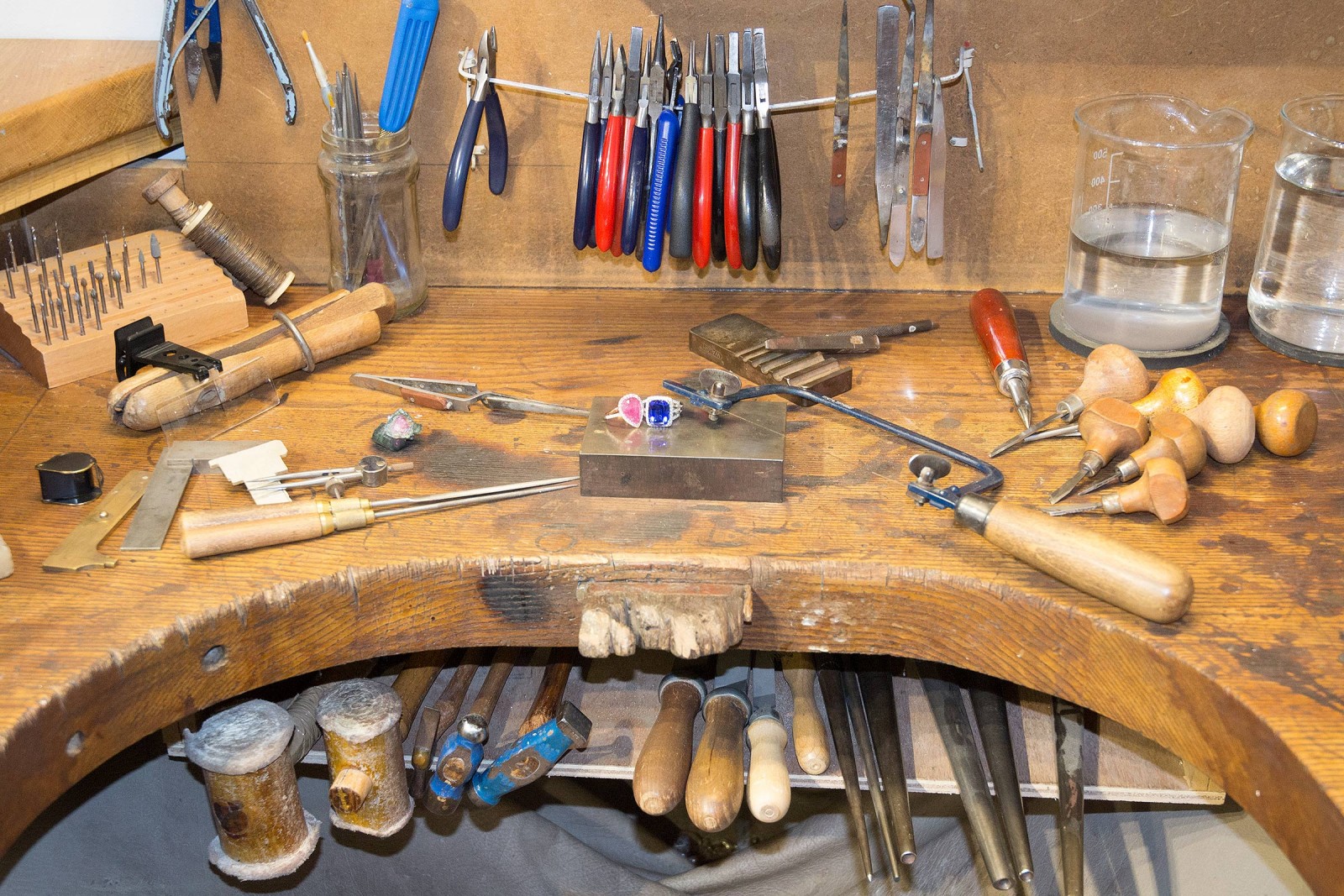 Simon's jewellery workbench, with his tools laid out and two finished rings on the bench block